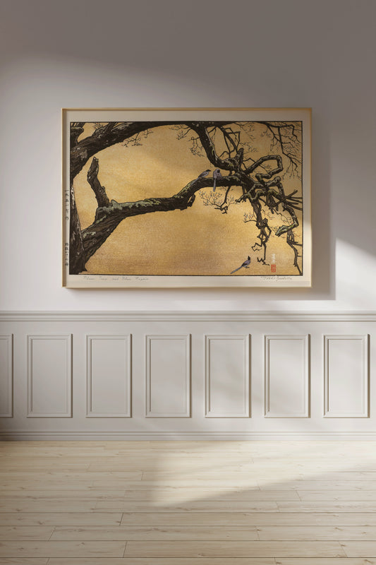 Toshi Yoshida's "Plum Tree and Blue Magpies" woodblock art in yellow gold, elegantly framed on a minimalist gallery wall.