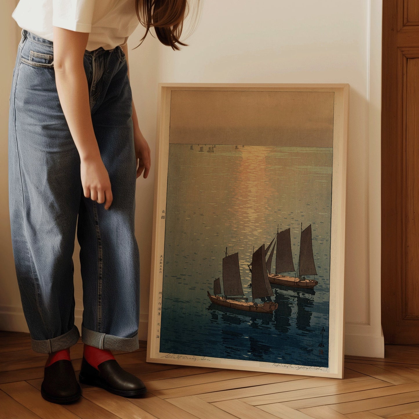 "Framed Hiroshi Yoshida Sailboats at Noon vintage Japanese woodblock print displayed by a person in casual jeans indoors"