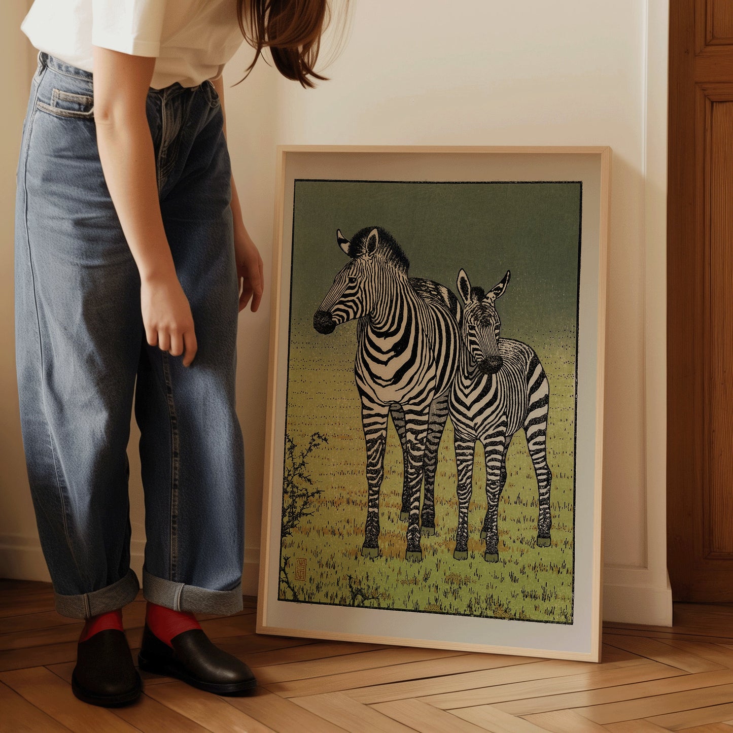 Vintage Toshi Yoshida zebra print in a light frame leaning against a wall with a person nearby, showcasing fine art details.