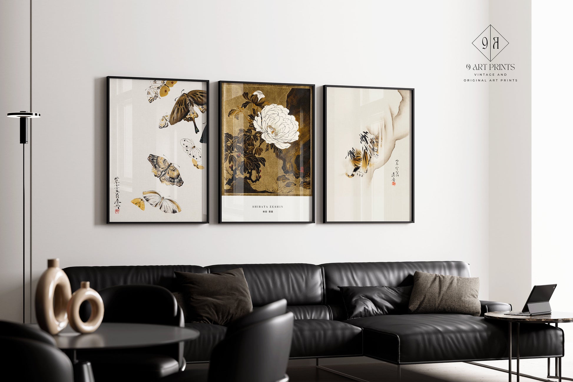 Shibata Zeshin minimalist prints of butterflies, peonies, and tiger on a wall above a black sofa; vintage Japanese art with gold.