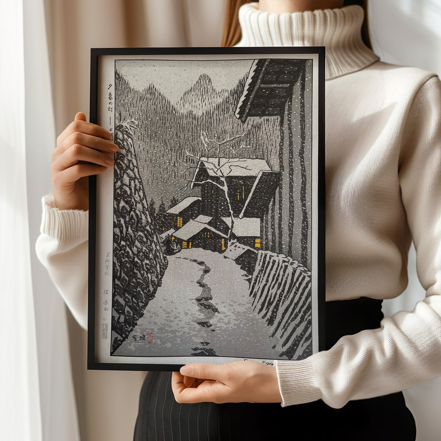 Woman holding framed "Light in the Evening Snow Country" Japanese Shin-Hanga art print with vintage neutral design.