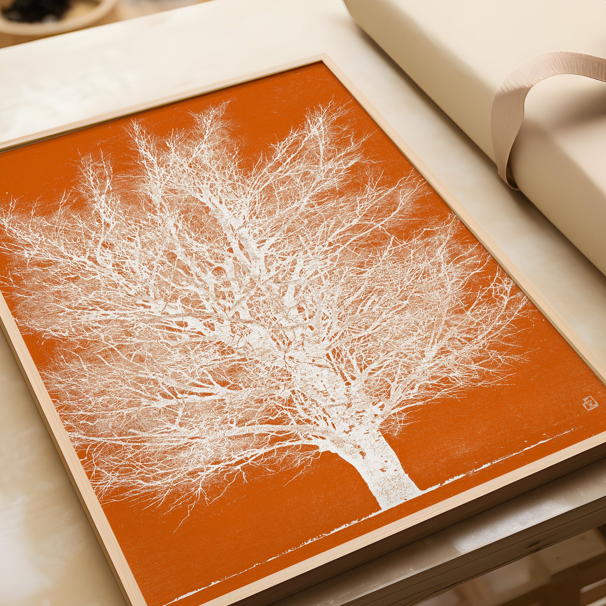 Joichi Hoshi Orange and White Tree woodblock art framed in nude oak on a table, showcasing vintage Japanese art style.