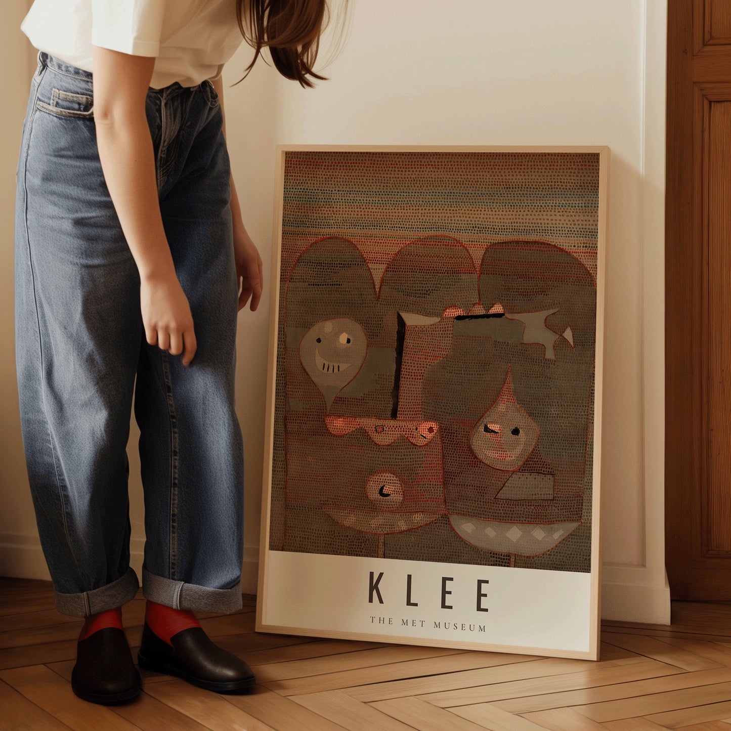 Woman admiring framed Paul Klee abstract art print, leaning against a wall, titled "Barbarian Sacrifice" from The Met Museum collection.