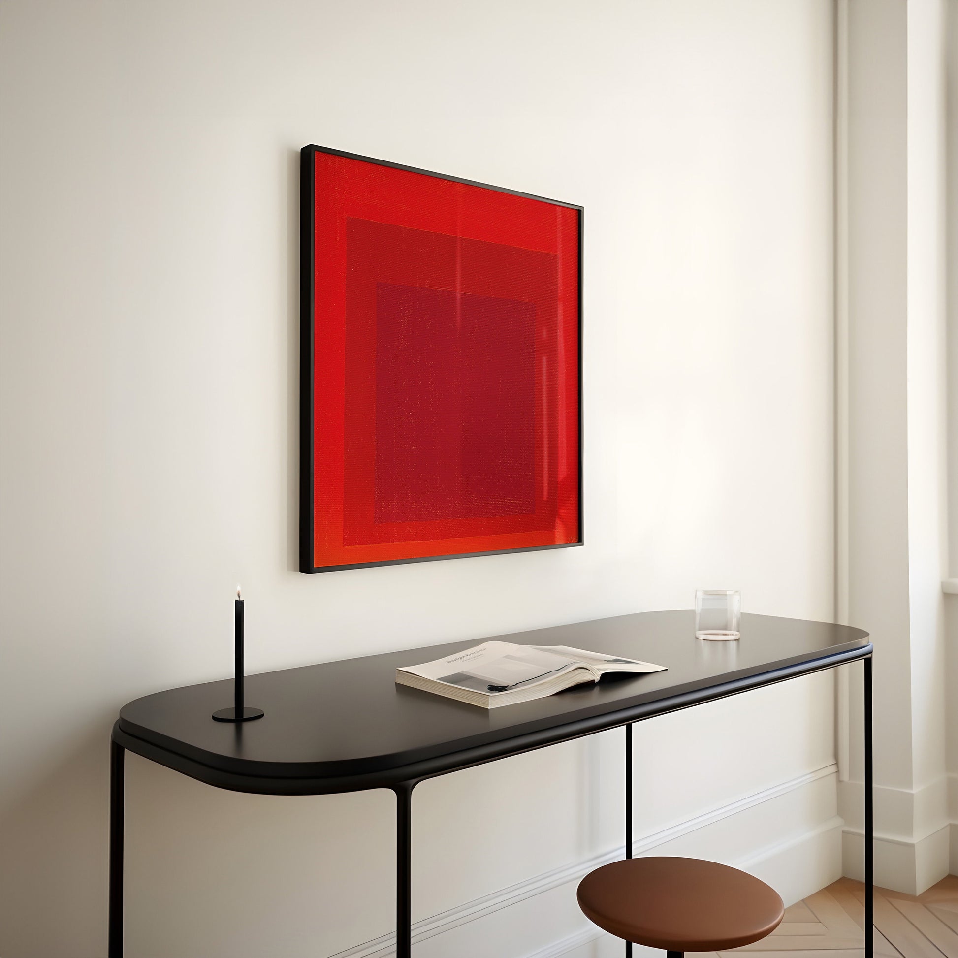 Mid-century modern red abstract art print on wall above sleek black desk, Josef Albers' Homage to the Square framed artwork.