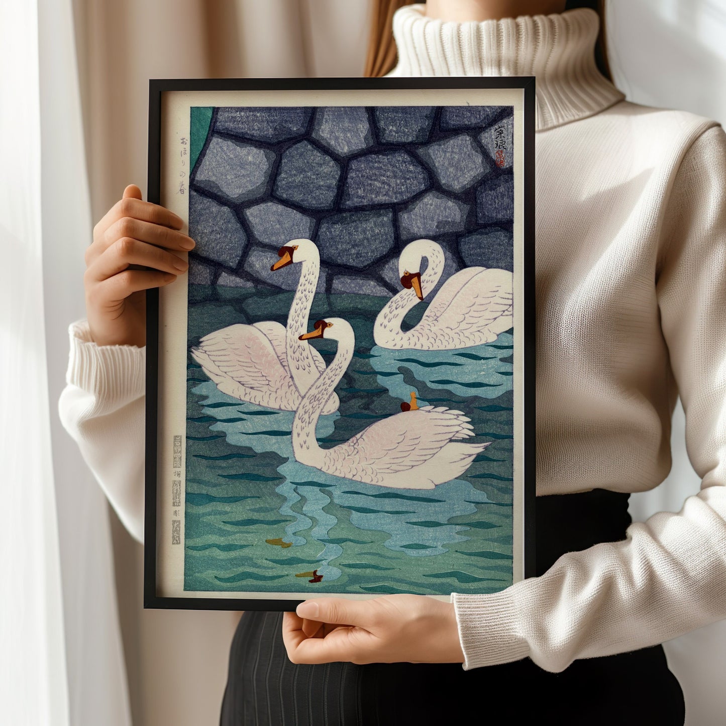 Person holding framed Shiro Kasamatsu Japanese woodblock print featuring swans in a moat.