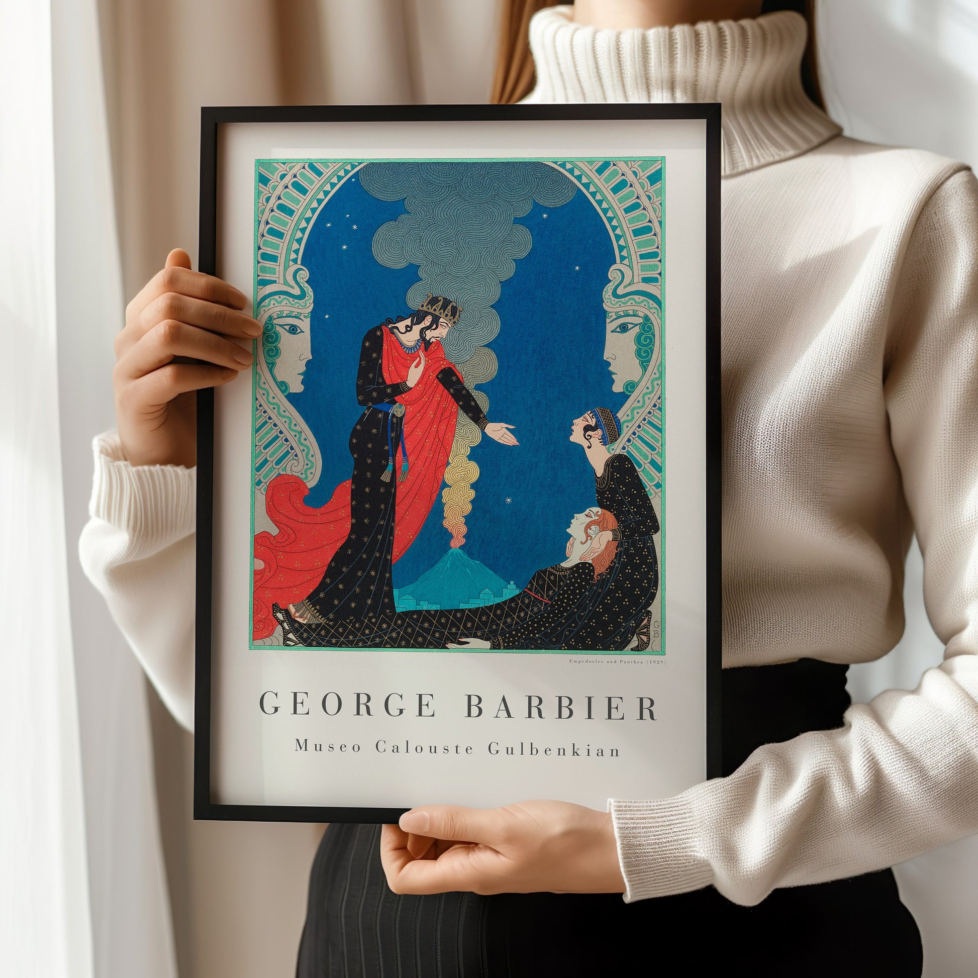 "George Barbier Emodecles and Pantea Art Deco Print displayed in frame, held by person in white turtleneck"