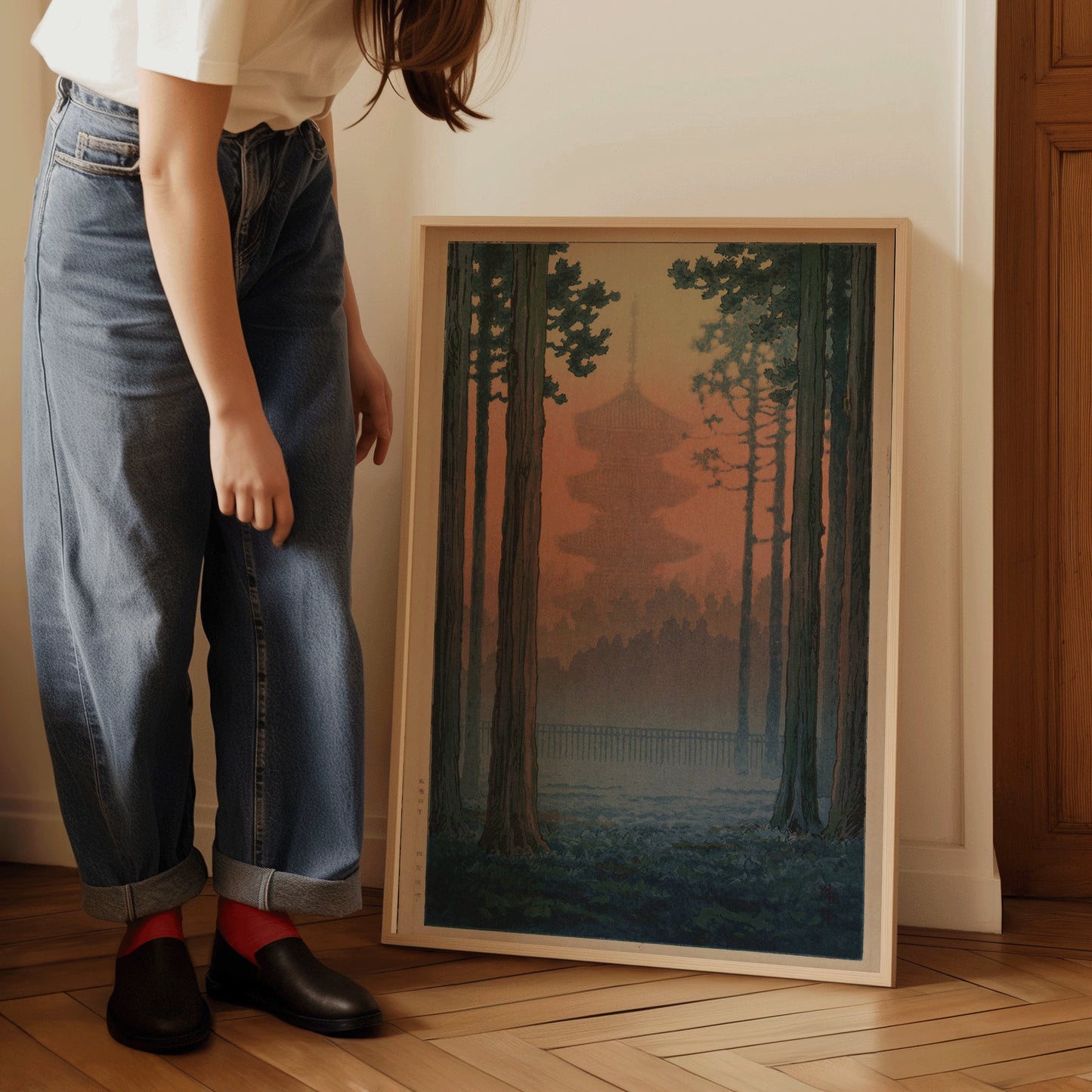 Person admiring framed Ito Yuhan Torii Gate in Bamboo Grove woodblock art in room setting.