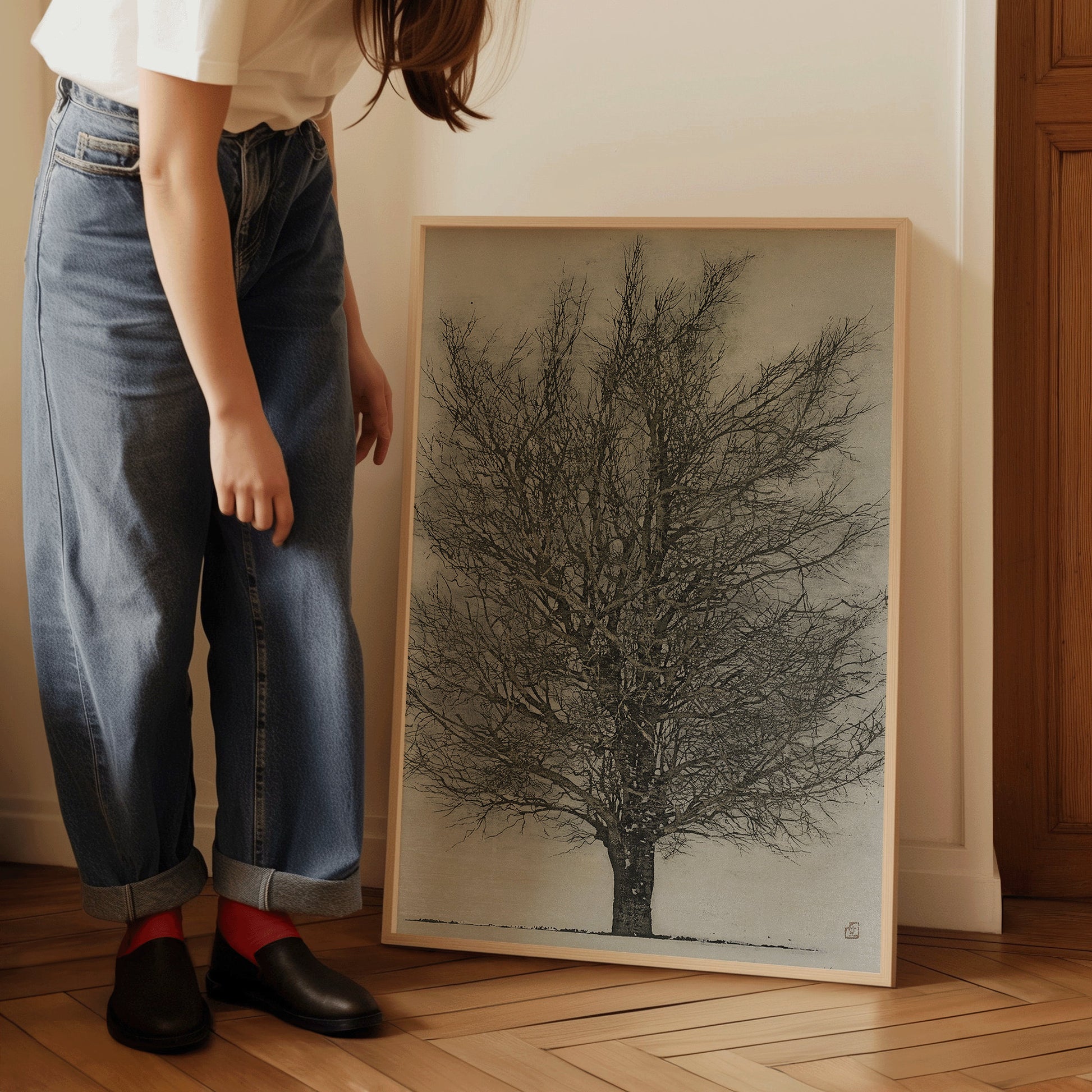 Joichi Hoshi's The Black Tree framed print leaned against a wall, person in jeans admiring vintage Japanese woodblock art