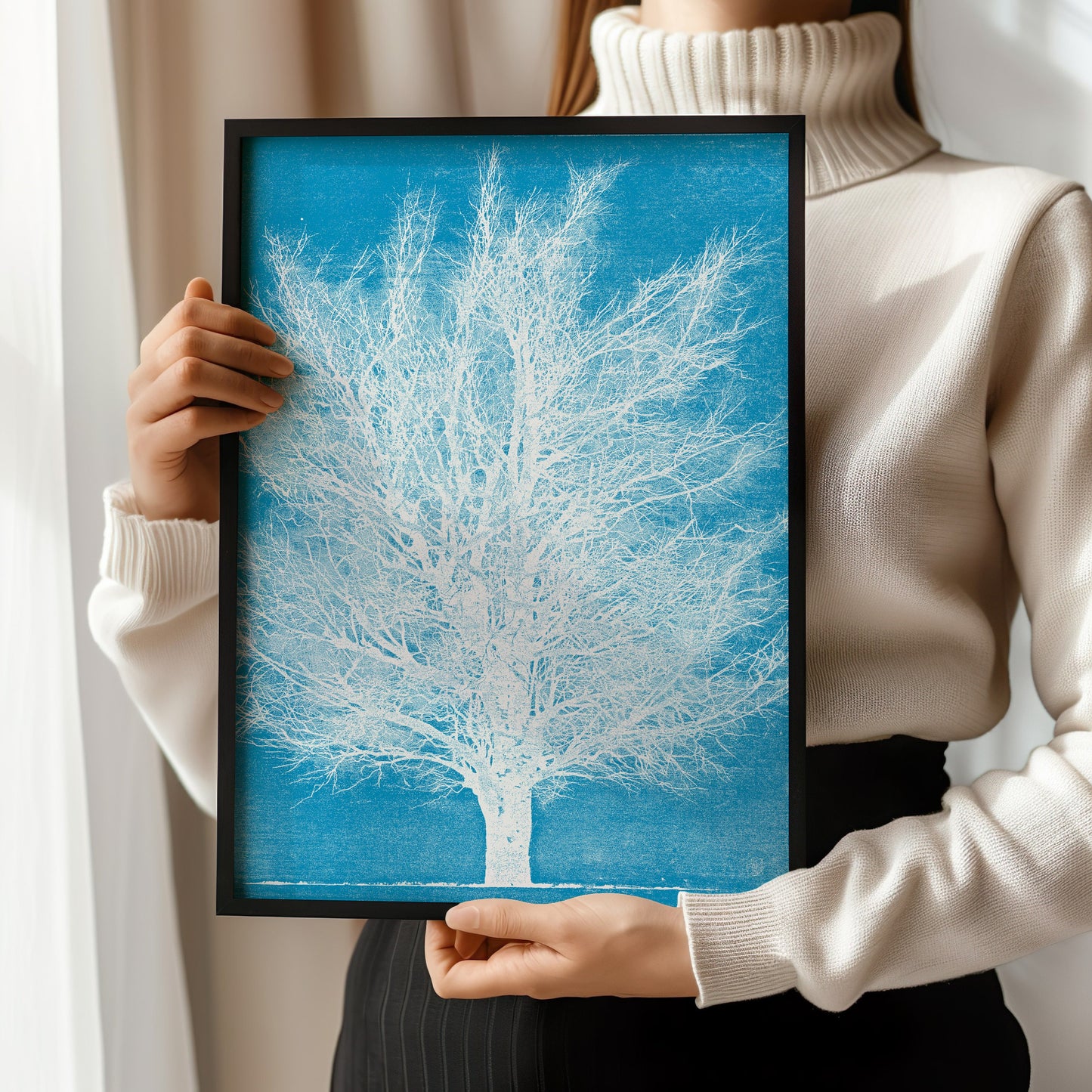 Woman holding framed Joichi Hoshi Ice Tree woodblock print against a light background.