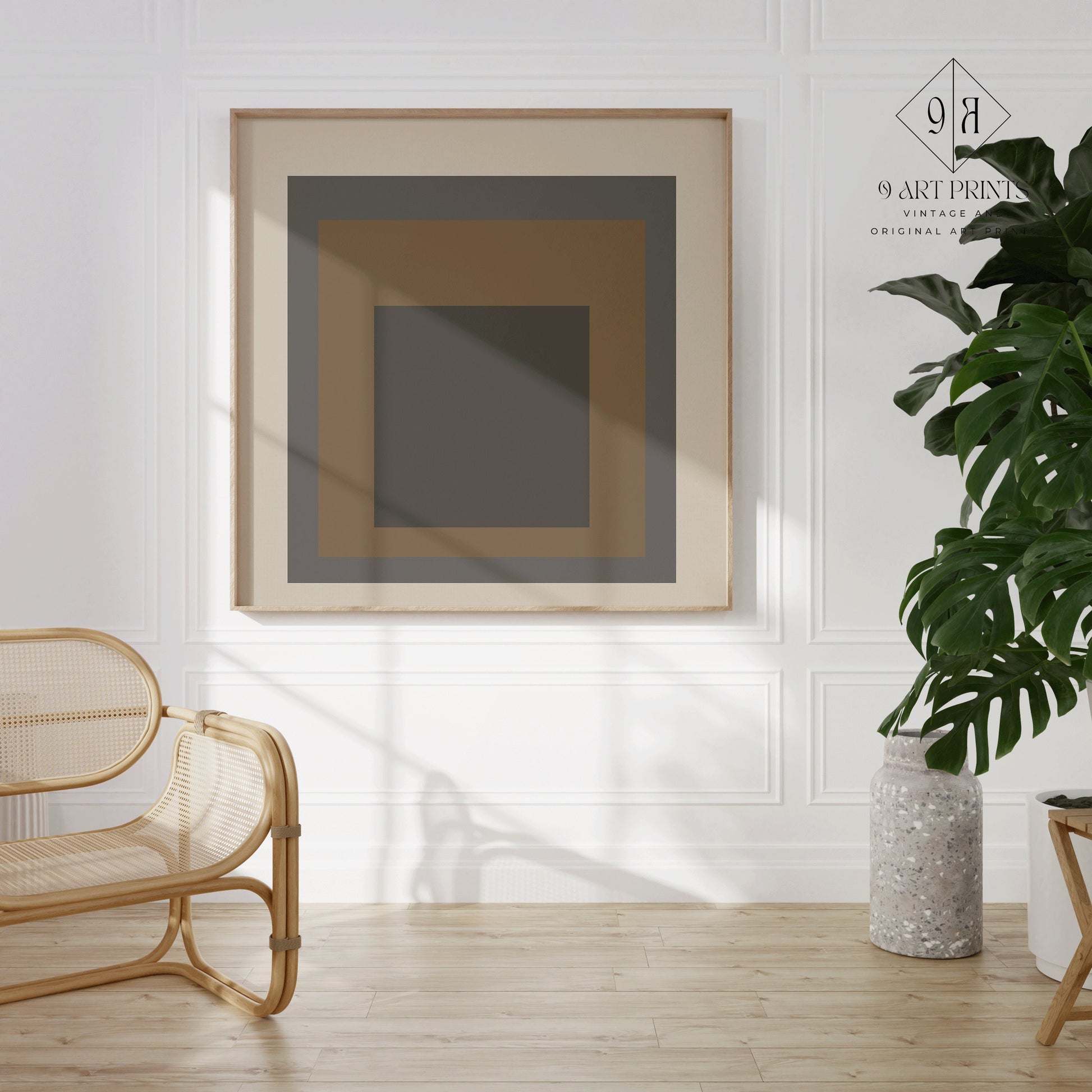 Beige, black, and brown mid-century modern art print in a minimalist room with a wicker chair and plant.