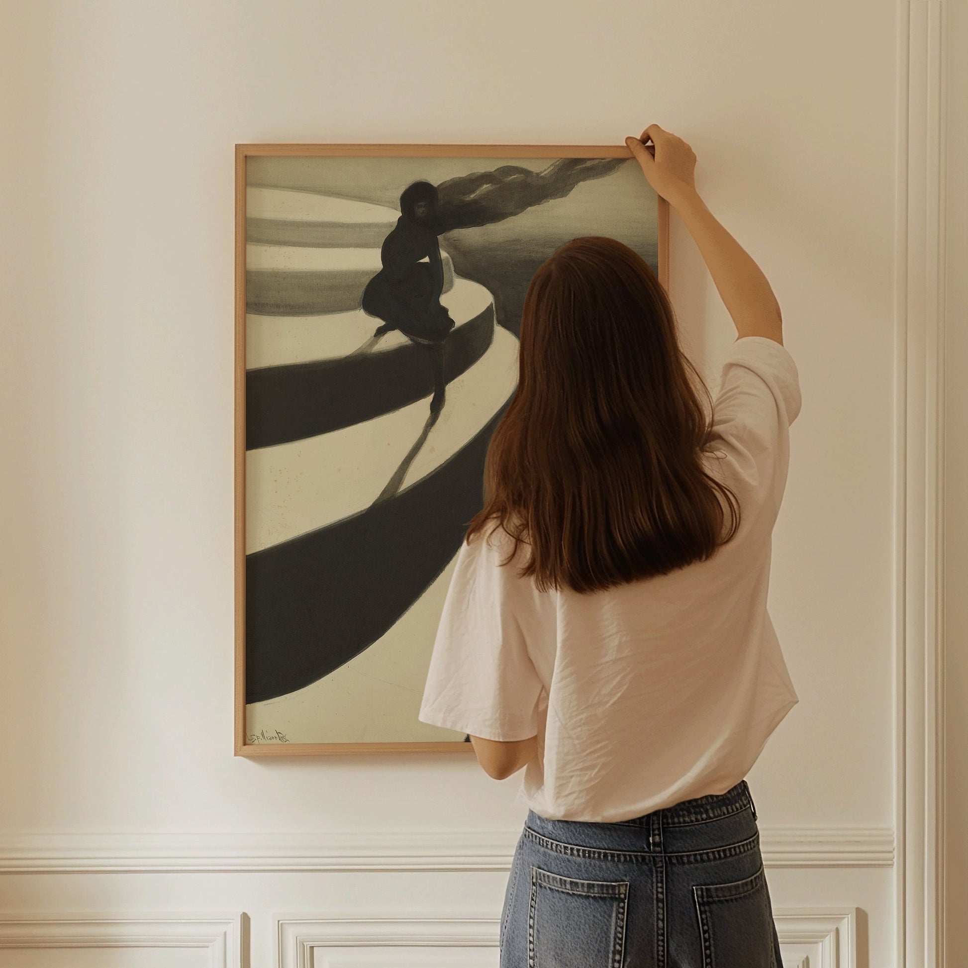 Woman hanging framed Leon Spillaert's Vertigo black and white art on wall