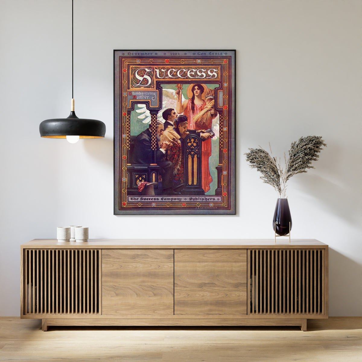 Framed art print of Success, Thanksgiving Number, November 1901 by J.C. Leyendecker, above a slatted wood sideboard