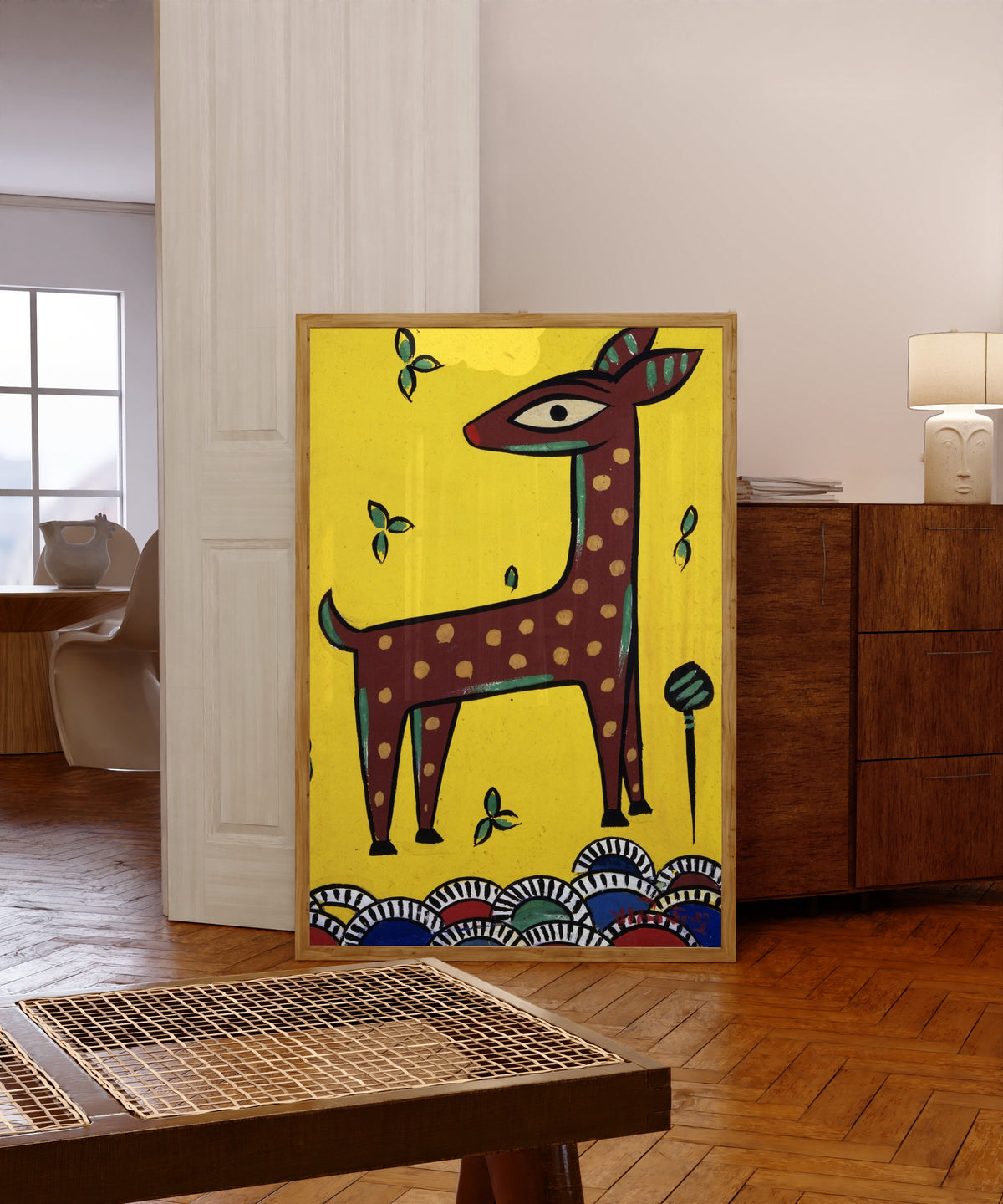 Framed art print of Fawn (Horinchhana) by Jamini Roy, in a light wood frame leaning in a warm room with a parquet floor