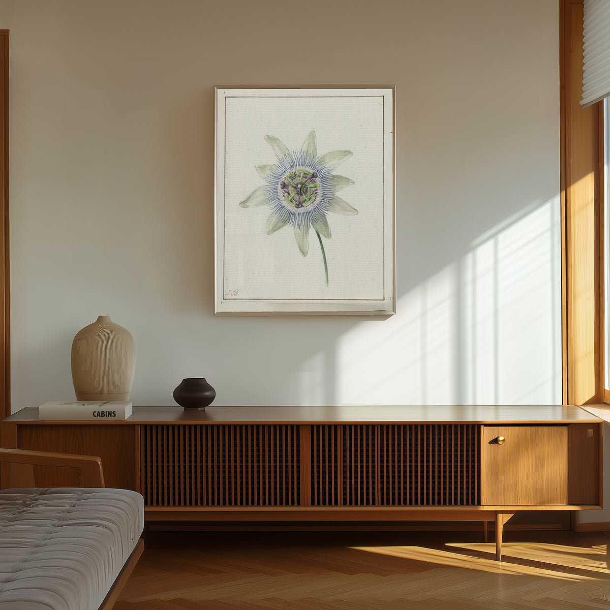 Framed art print of Passion Flower by Jean Bernard, in a thin light frame on a sunlit wall above a wooden sideboard