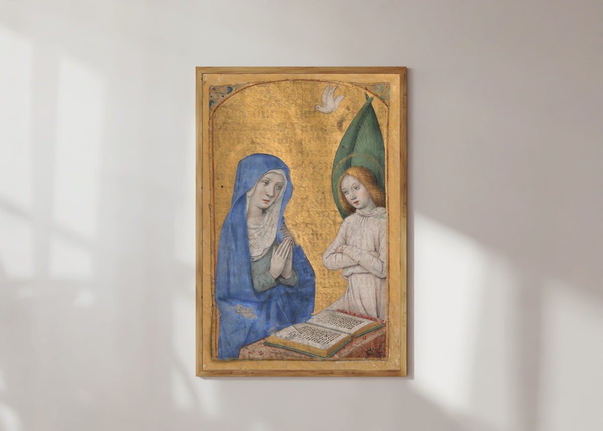 Framed art print of Book of Hours: The Annunciation by Jean Bourdichon, in a light wood frame on a sunlit white wall