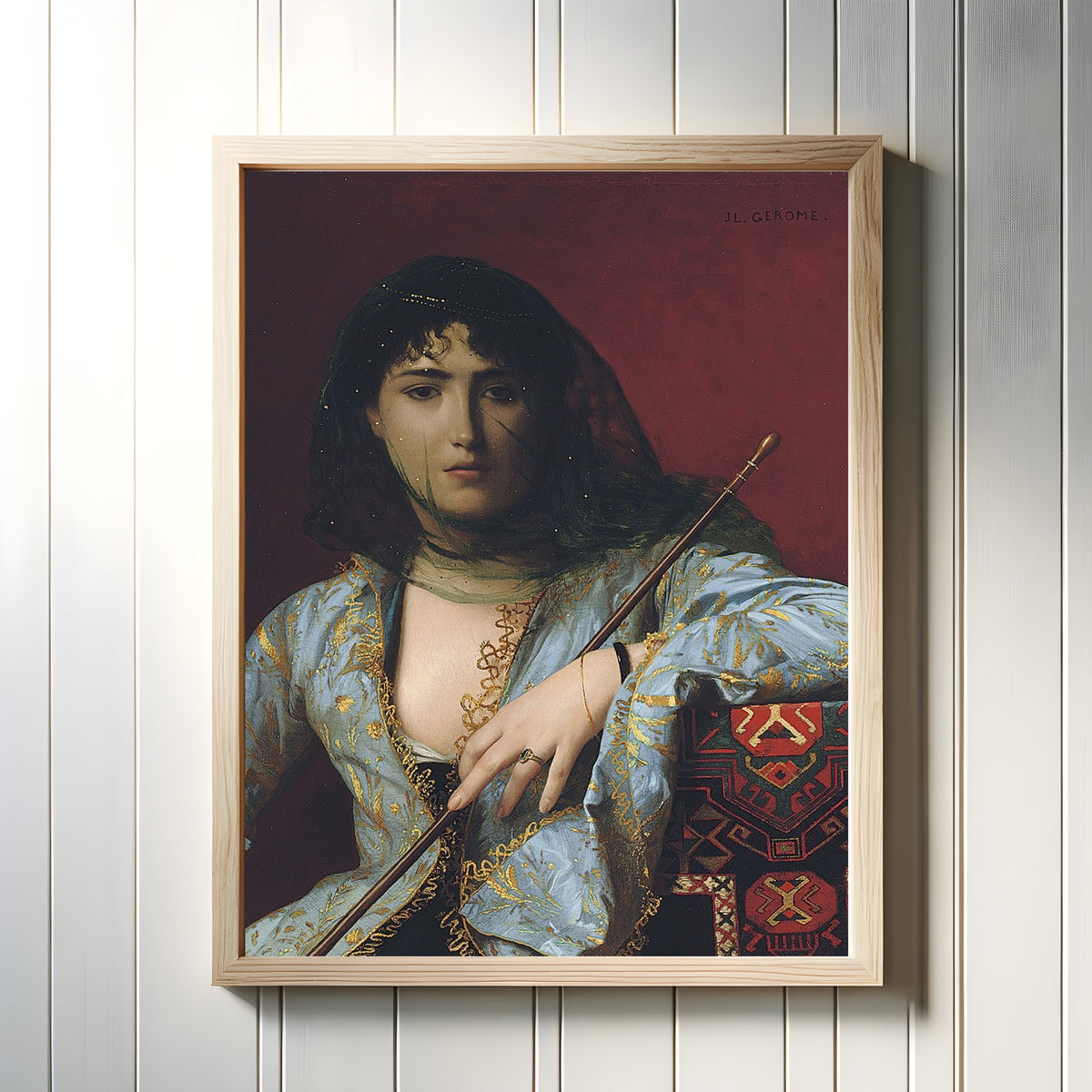 Framed art print of Veiled Circassian Beauty by Jean-Léon Gérôme, in a light wood frame on a white panelled wall