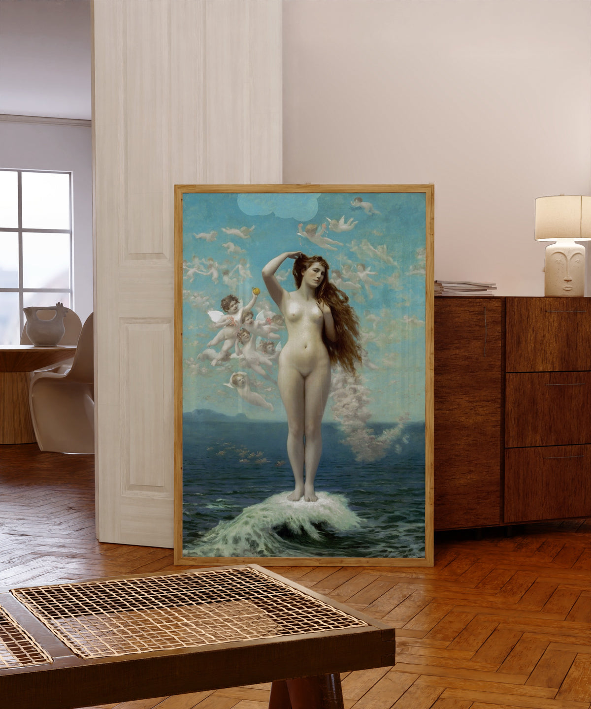 Framed art print of Venus Rising (The Star) by Jean-Léon Gérôme, in a light wood frame leaning in a warm room with a parquet floor