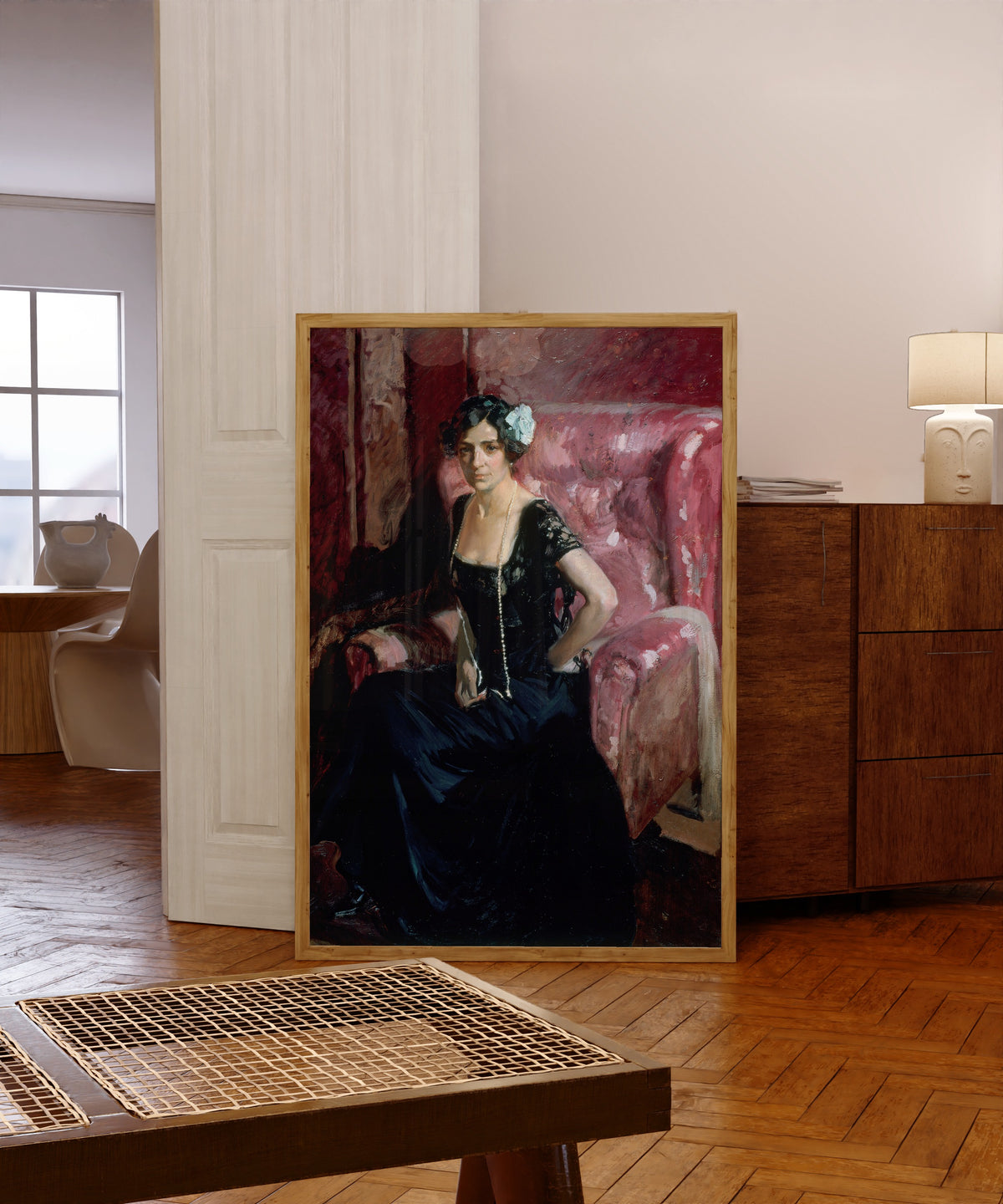 Framed art print of Clotilde in Evening Dress by Joaquín Sorolla, in a light wood frame leaning in a warm room with a parquet floor