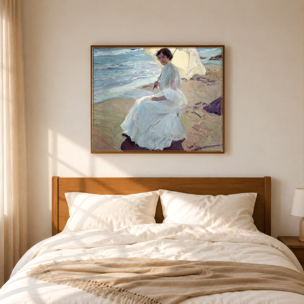 Framed art print of Clotilde on the Beach by Joaquín Sorolla, in a slim wood frame above a bed in a sunlit bedroom