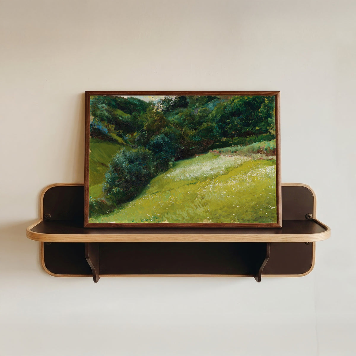 Framed art print of Field in Asturias, San Esteban de Pravia by Joaquín Sorolla, in a dark wood frame resting on a wall shelf