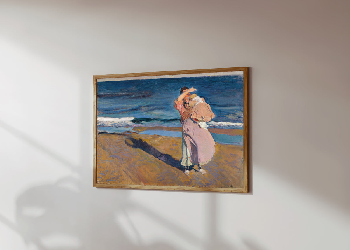Framed art print of Fisherwoman with her Son by Joaquín Sorolla, in a light wood frame on a sunlit white wall, seen at a slight angle