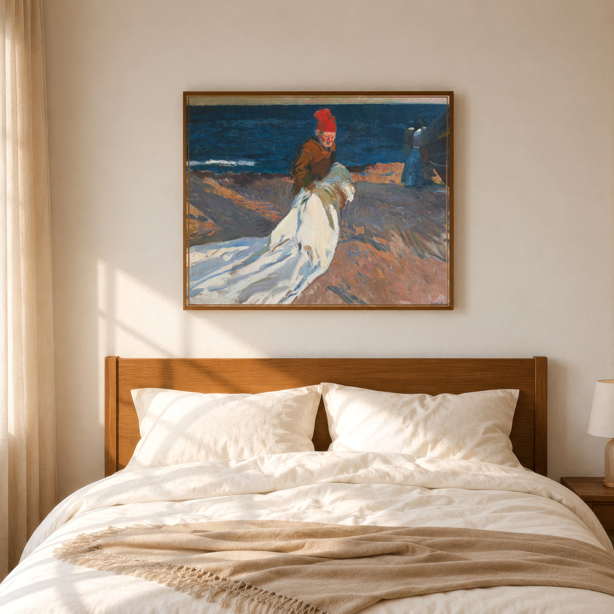 Framed art print of Gathering the Sail, Valencia Beach by Joaquín Sorolla, in a slim wood frame above a bed in a sunlit bedroom