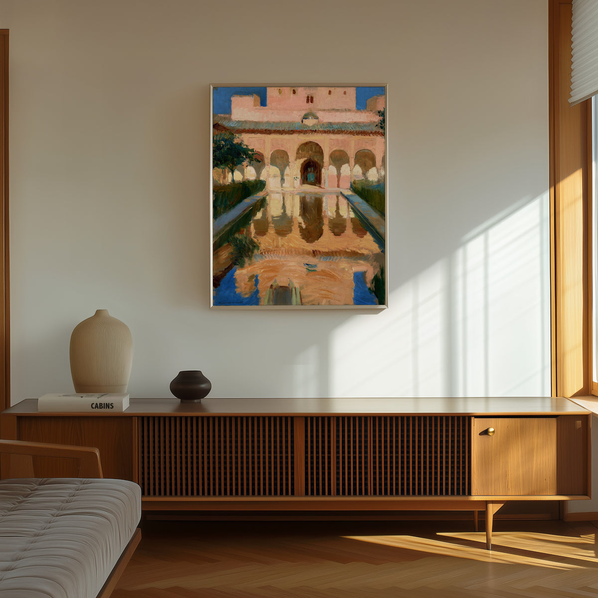 Framed art print of Hall of the Ambassadors, Alhambra, Granada by Joaquín Sorolla, in a thin light frame on a sunlit wall above a wooden sideboard