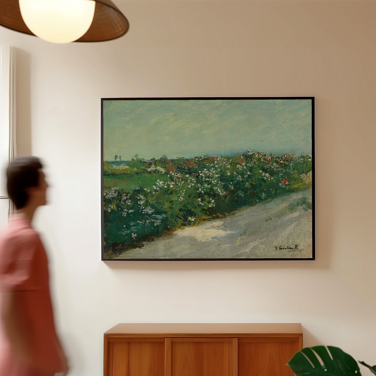 Framed art print of Malvarrosa by Joaquín Sorolla, in a slim black frame on a warm wall in a sunlit room