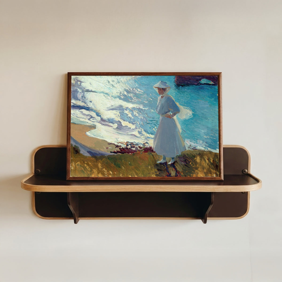 Framed art print of María on the Beach at Biarritz (Contre-jour) by Joaquín Sorolla, in a dark wood frame resting on a wall shelf