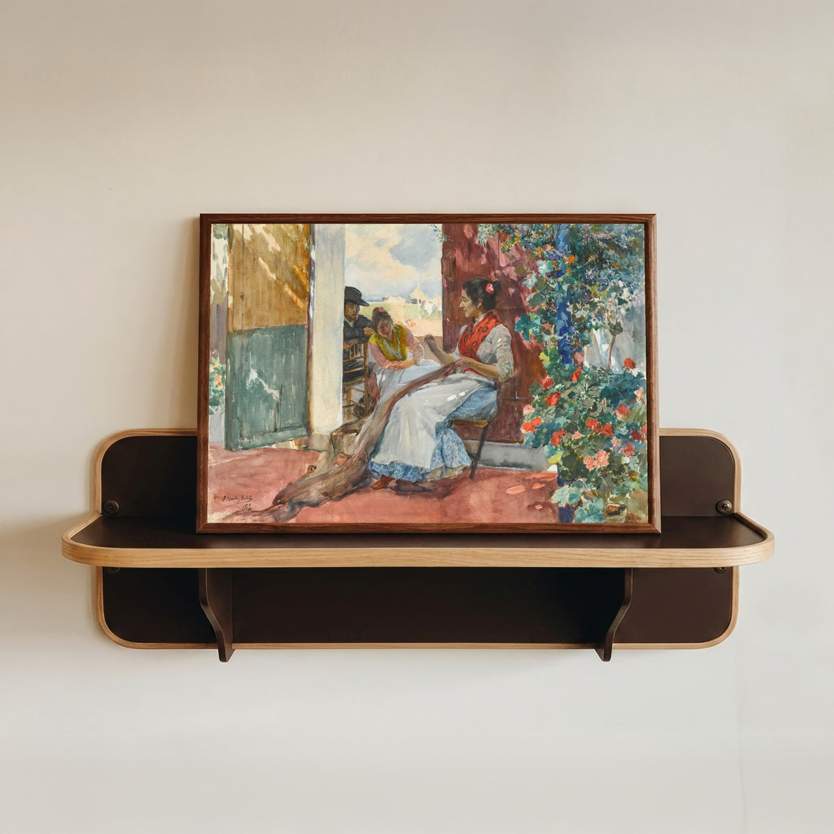Framed art print of Mending the Nets by Joaquín Sorolla, in a dark wood frame resting on a wall shelf