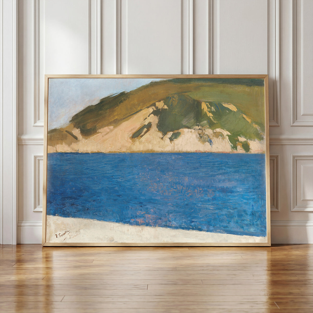 Framed art print of Monte Ulía, San Sebastián by Joaquín Sorolla, in a light wood frame leaning against a panelled white wall