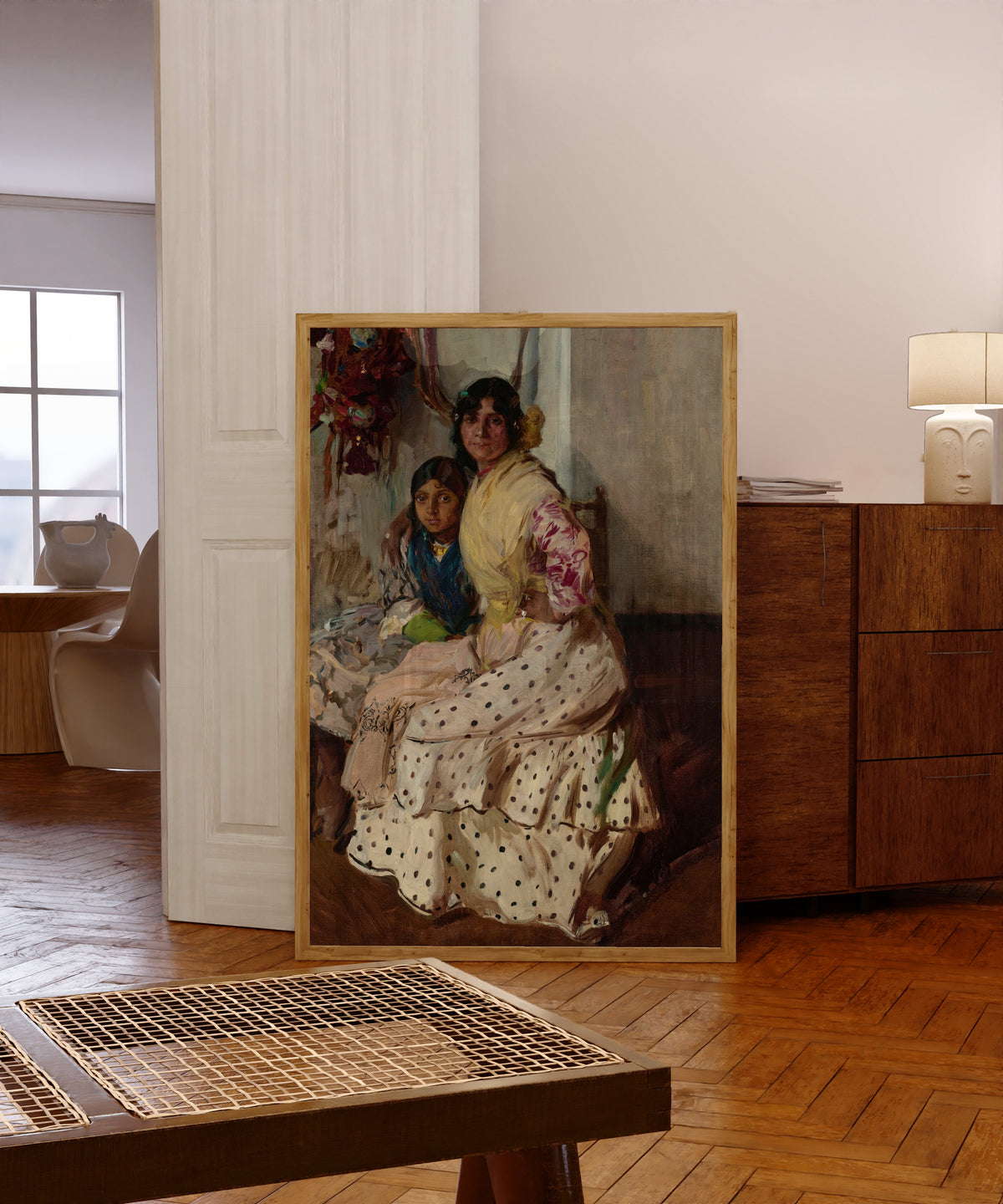 Framed art print of Pepilla the Gypsy and Her Daughter by Joaquín Sorolla, in a light wood frame leaning in a warm room with a parquet floor