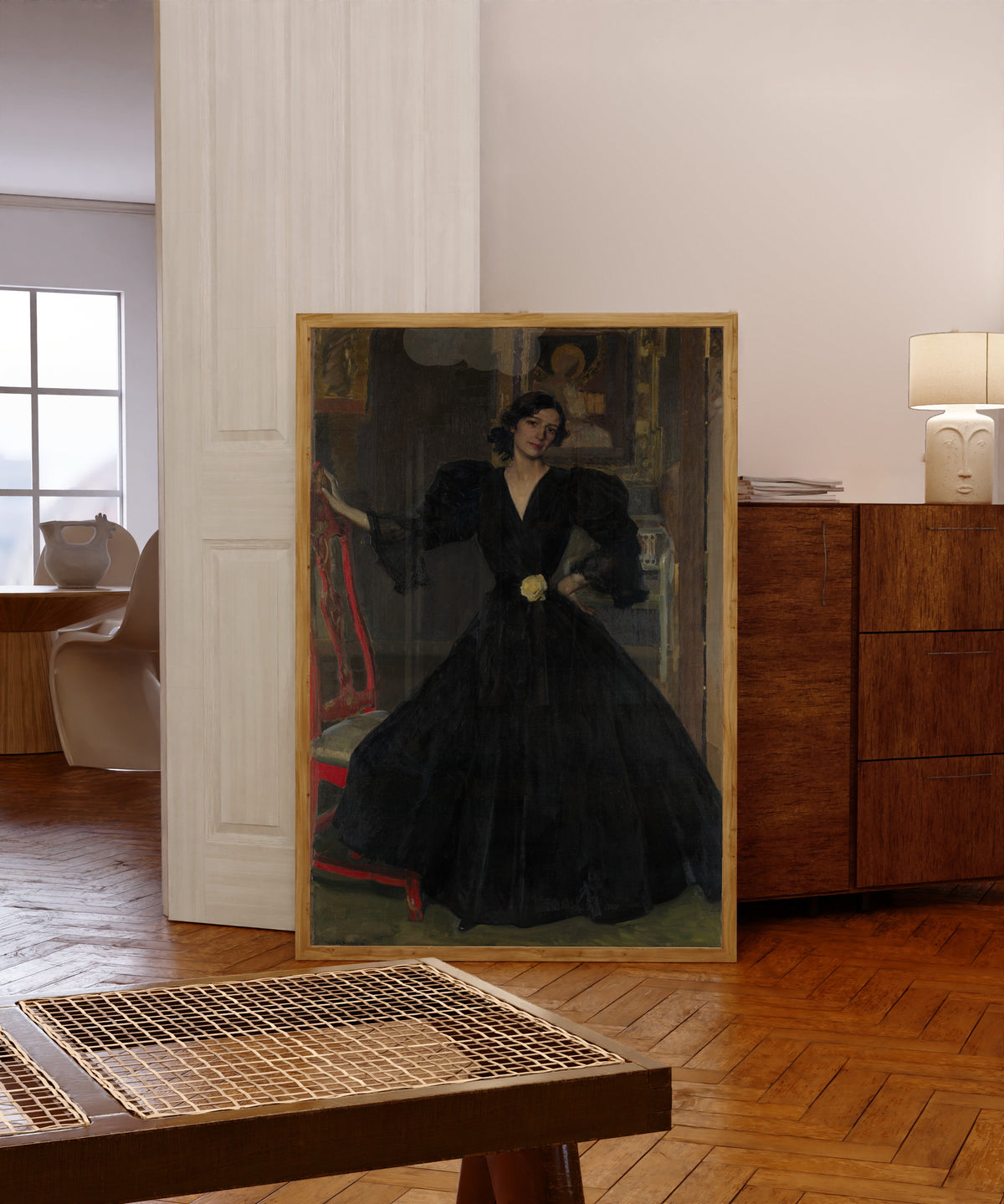Framed art print of Señora de Sorolla in Black by Joaquín Sorolla, in a light wood frame leaning in a warm room with a parquet floor