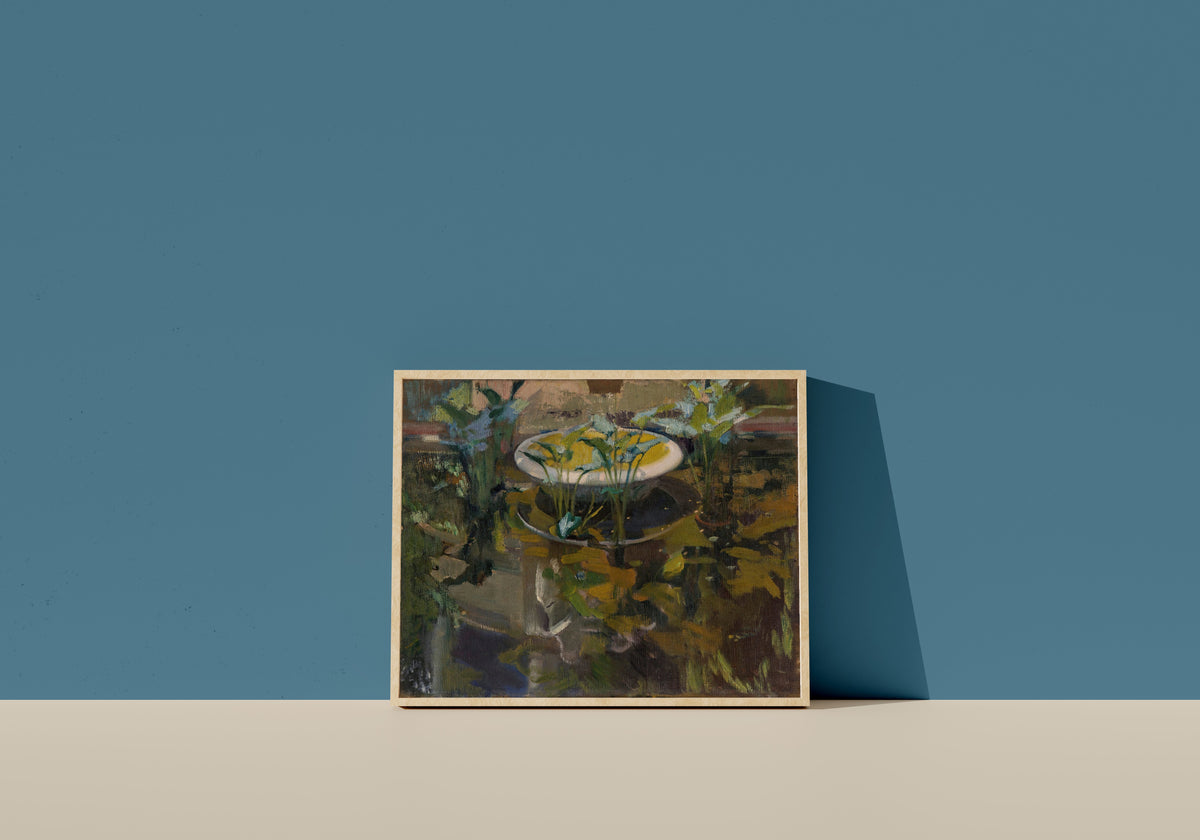 Framed art print of The Fountain of Confidences, Garden of the Sorolla House by Joaquín Sorolla, in a light wood frame leaning on a blue wall