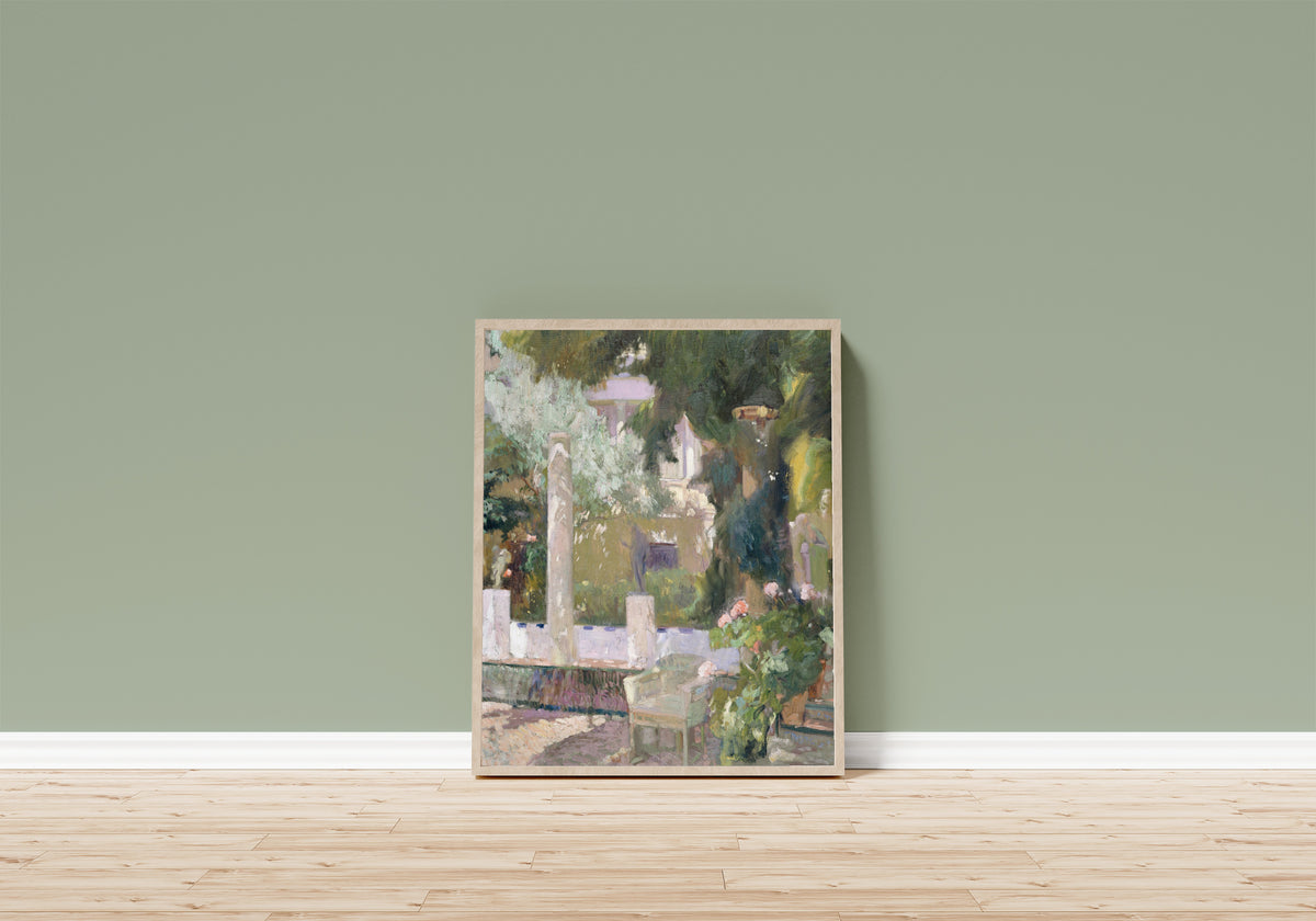 Framed art print of The Gardens at the Sorolla Family House by Joaquín Sorolla, in a light wood frame leaning on a sage green wall above a wooden floor