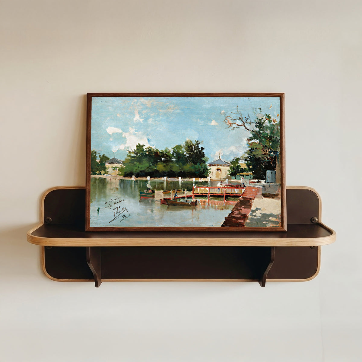 Framed art print of The Jetty in the Retiro Gardens, Madrid by Joaquín Sorolla, in a dark wood frame resting on a wall shelf