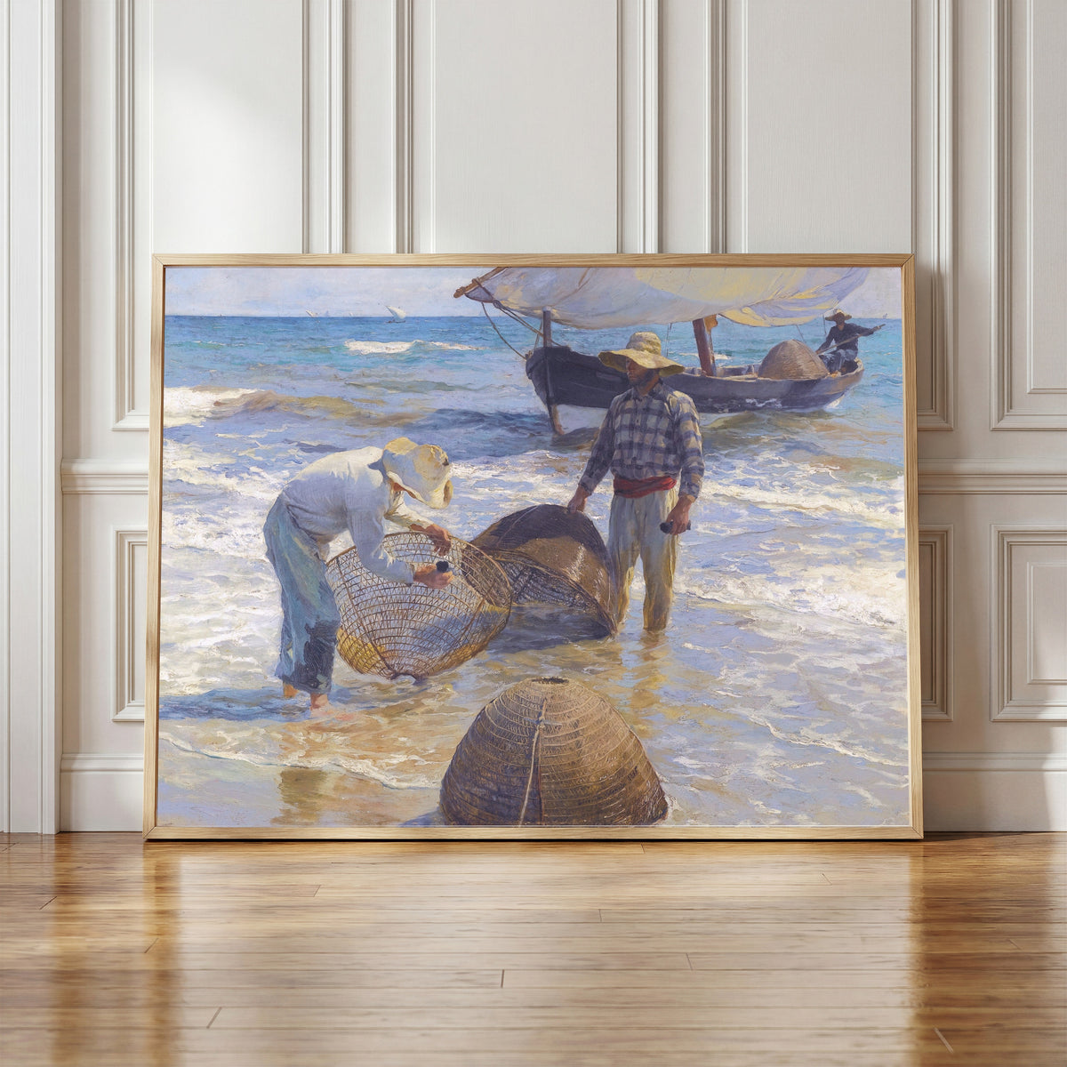 Framed art print of Valencian Fishermen by Joaquín Sorolla, in a light wood frame leaning against a panelled white wall