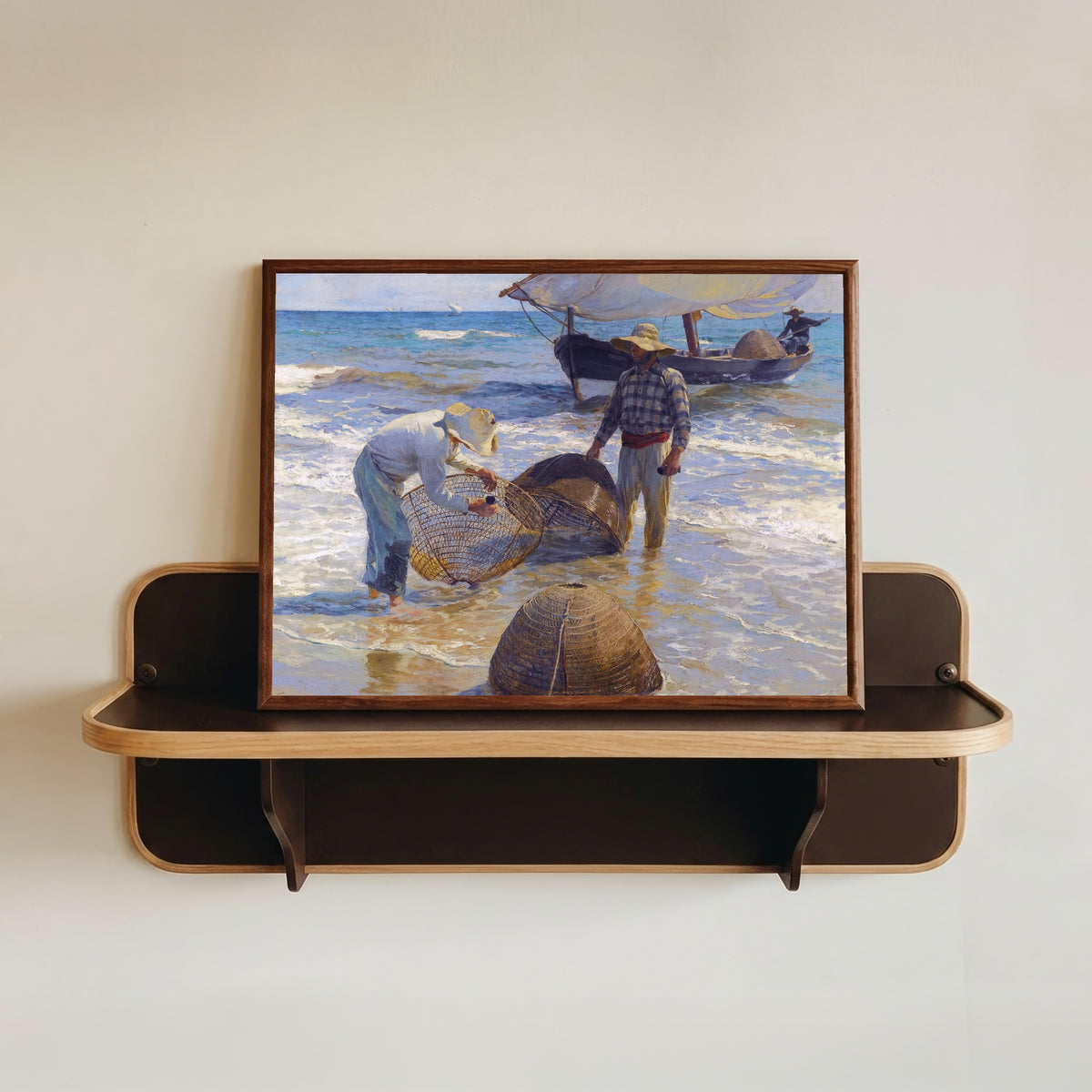 Framed art print of Valencian Fishermen by Joaquín Sorolla, in a dark wood frame resting on a wall shelf