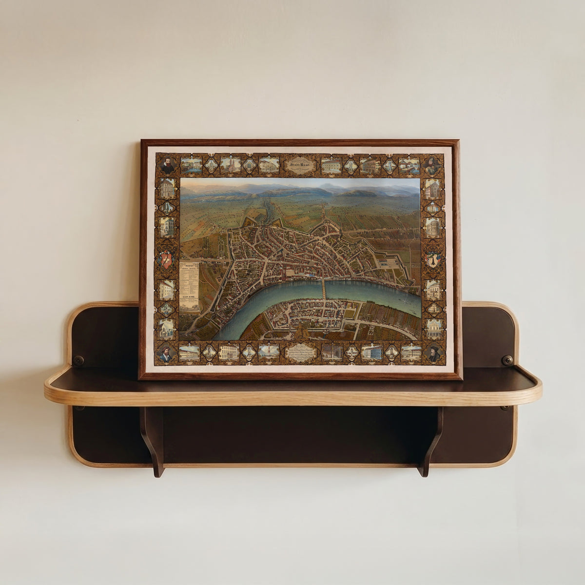 Framed art print of Malerischer Plan der Stadt Basel by Johann Friedrich Maehly, in a dark wood frame resting on a wall shelf