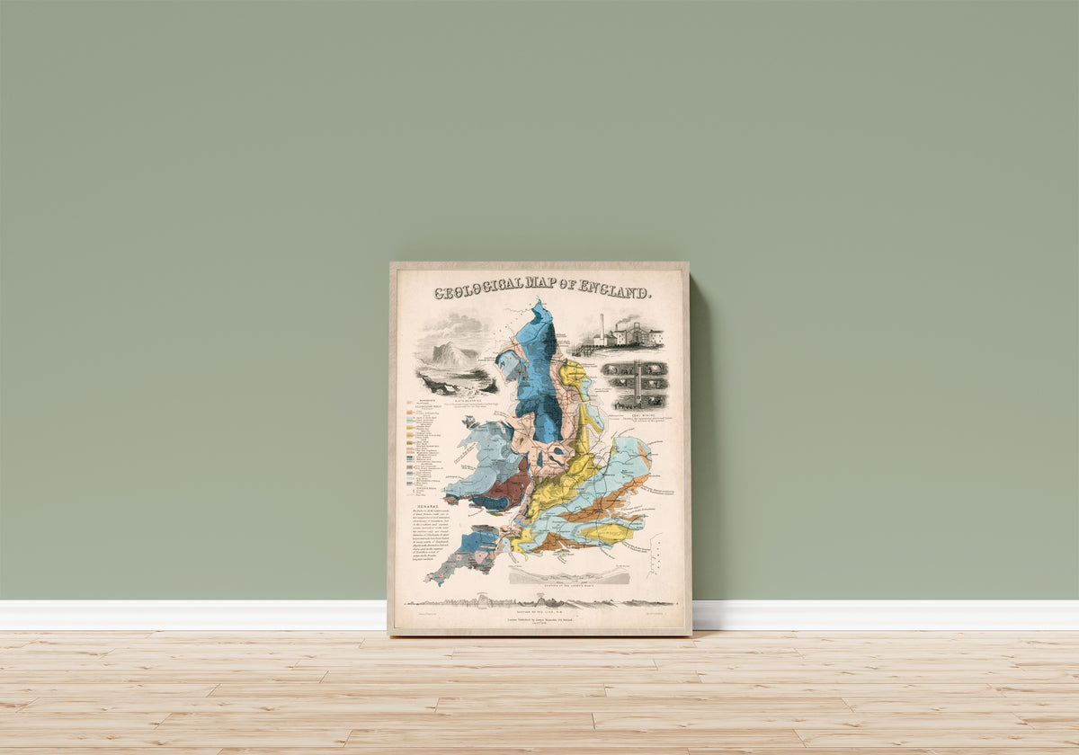 Framed art print of Geological Map of England by John Emslie, in a light wood frame leaning on a sage green wall above a wooden floor