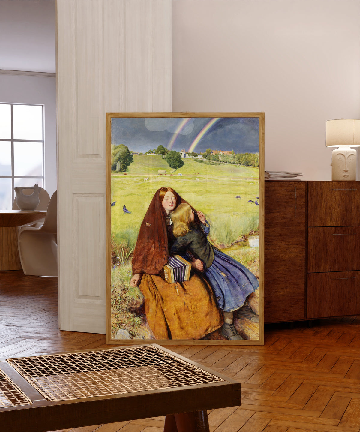 Framed art print of The Blind Girl by John Everett Millais, in a light wood frame leaning in a warm room with a parquet floor