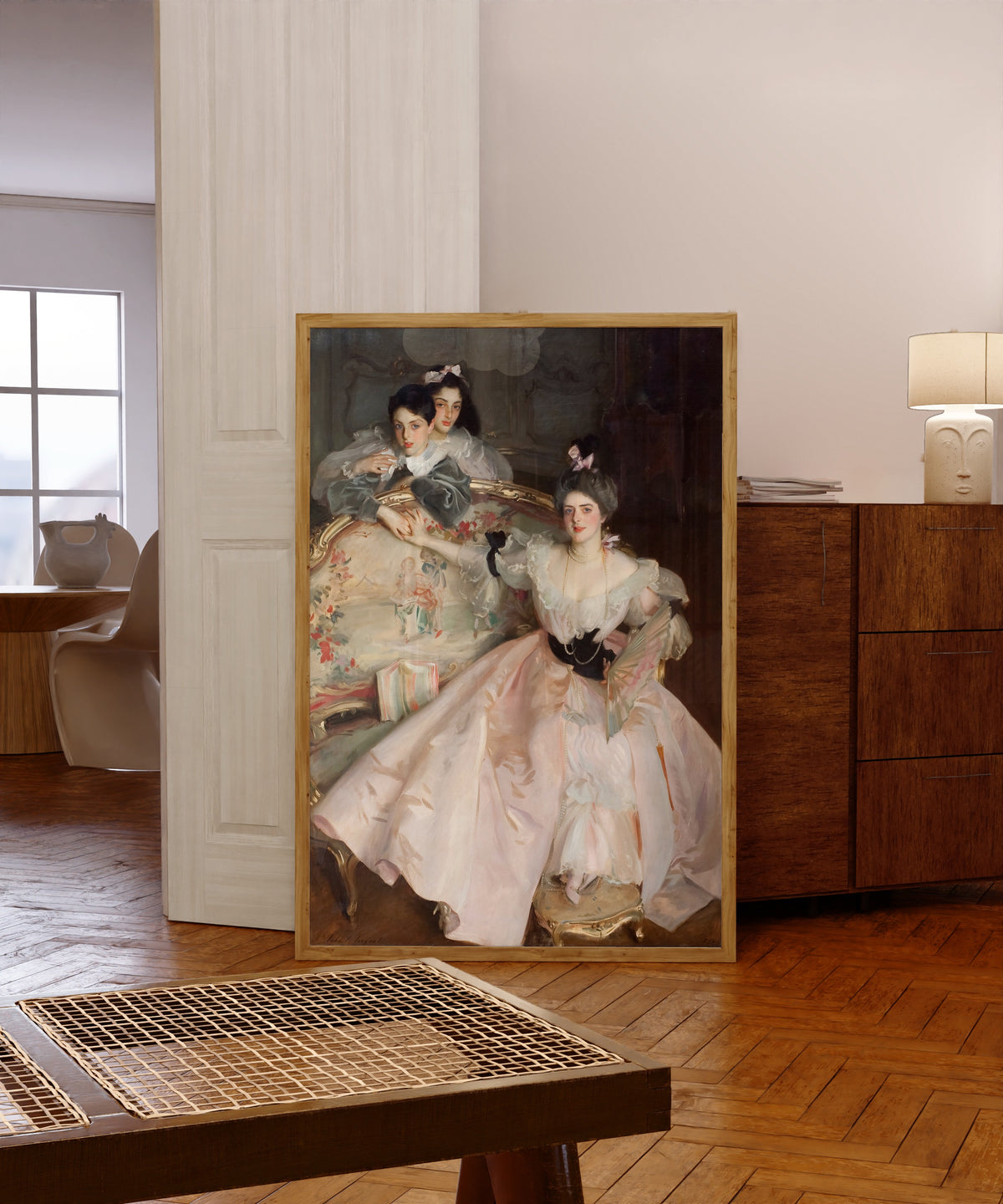 Framed art print of Mrs Carl Meyer and Her Children by John Singer Sargent, in a light wood frame leaning in a warm room with a parquet floor