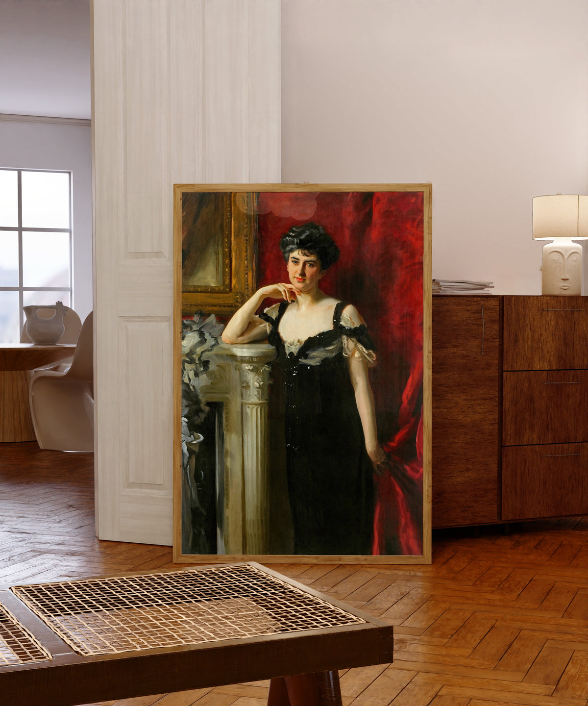 Framed art print of Mrs. John C. Tomlinson by John Singer Sargent, in a light wood frame leaning in a warm room with a parquet floor