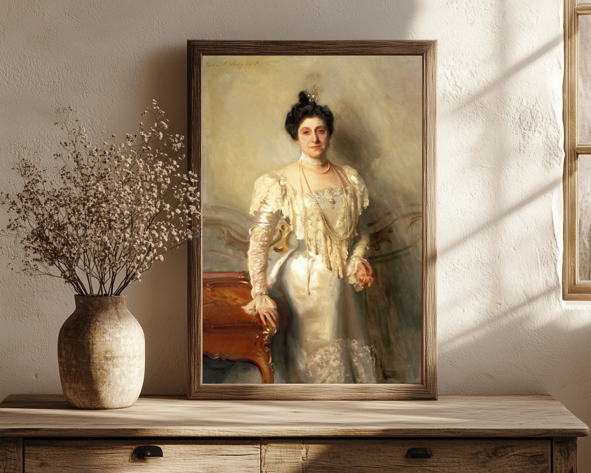 Framed art print of Portrait of Mrs. Asher B. Wertheimer by John Singer Sargent, in a dark wood frame leaning on a rustic console beside dried flowers