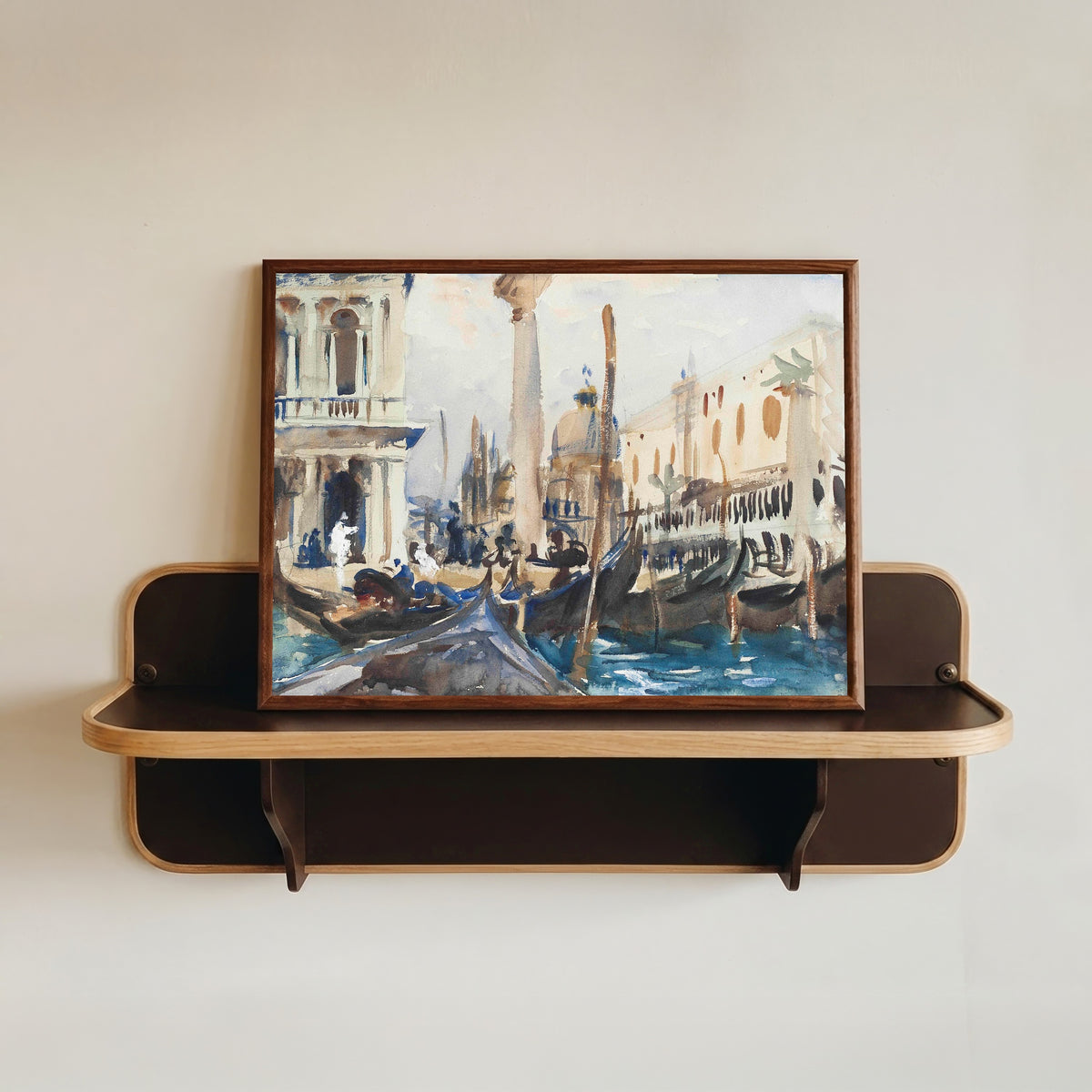 Framed art print of The Piazzetta with Gondolas by John Singer Sargent, in a dark wood frame resting on a wall shelf