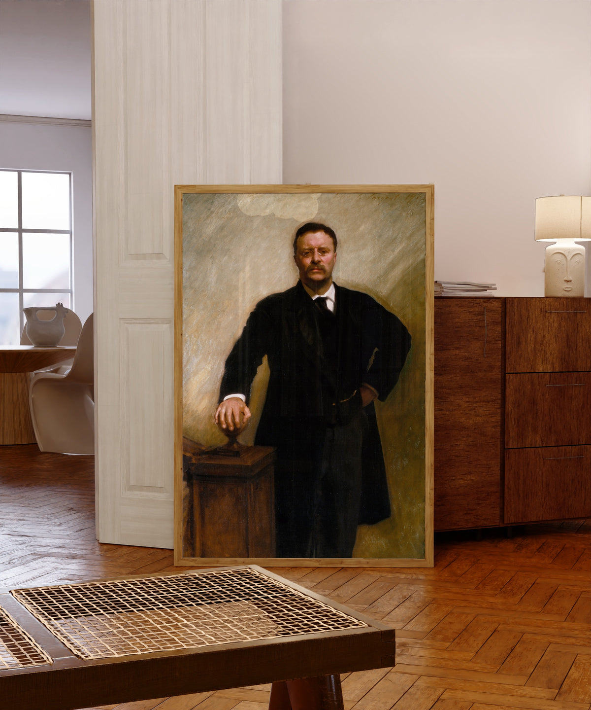 Framed art print of Theodore Roosevelt by John Singer Sargent, in a light wood frame leaning in a warm room with a parquet floor
