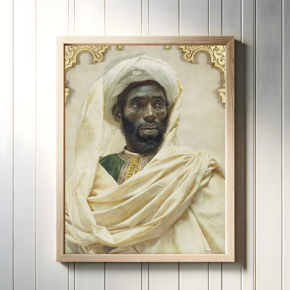 Framed art print of Moorish Man by Josep Tapiró Baró, in a light wood frame on a white panelled wall