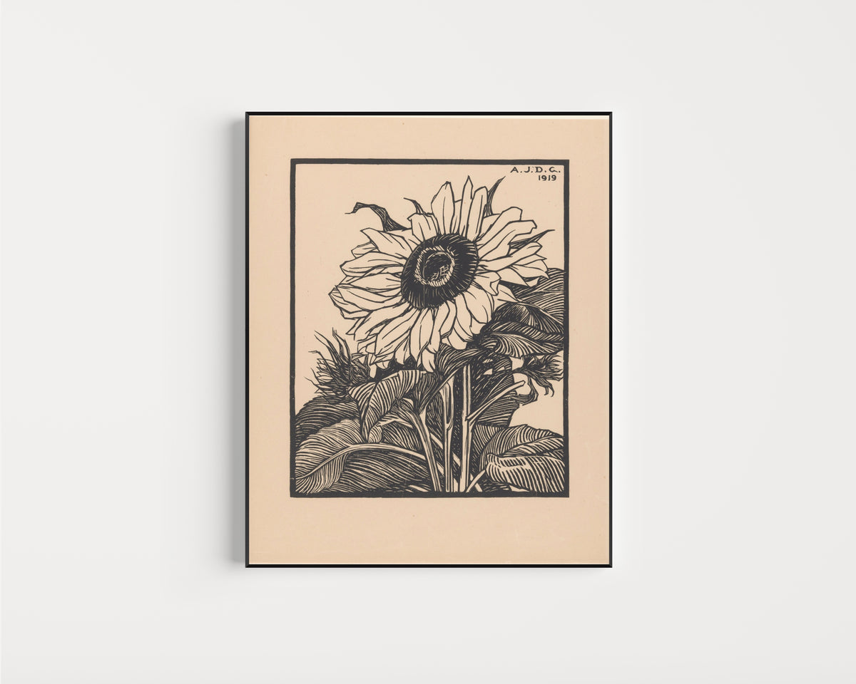 Framed art print of Sunflower by Julie de Graag, in a slim black frame on a plain white wall