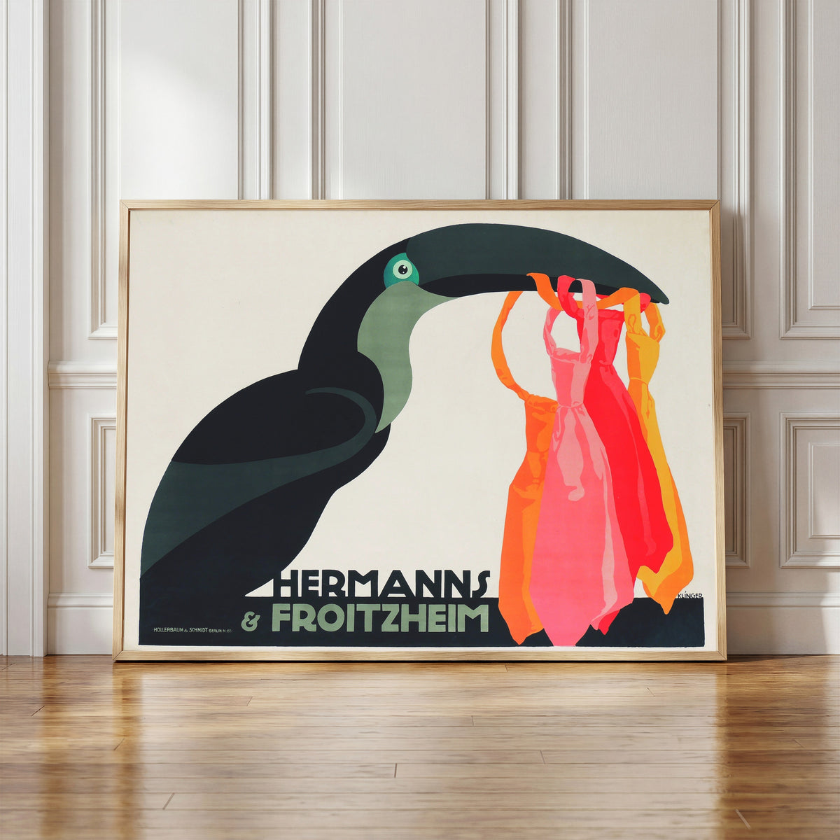 Framed art print of Hermanns & Froitzheim by Julius Klinger, in a light wood frame leaning against a panelled white wall
