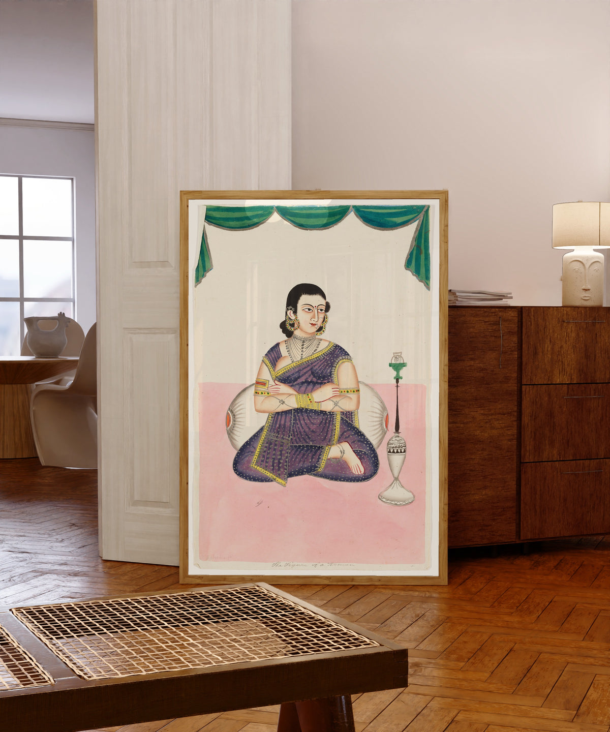 Framed art print of Portrait of a Woman by Kalighat painter, in a light wood frame leaning in a warm room with a parquet floor